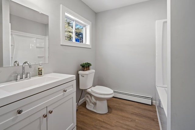 full bathroom with baseboards, toilet, baseboard heating, wood finished floors, and vanity