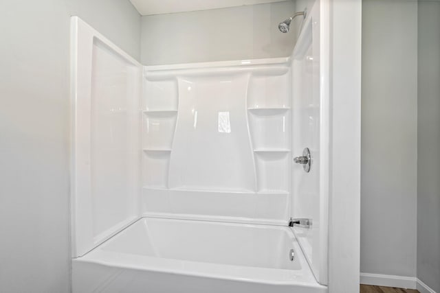 full bath featuring shower / bath combination and baseboards