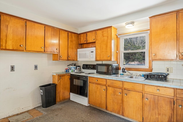 kitchen with electric range, white microwave, brown cabinetry, a sink, and black microwave