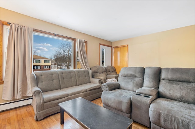 living room with light wood-type flooring and baseboard heating