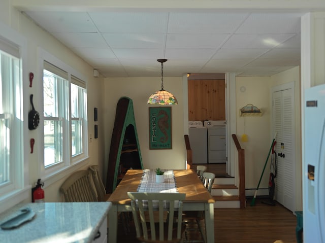 dining area with a drop ceiling, wood finished floors, and washer and clothes dryer