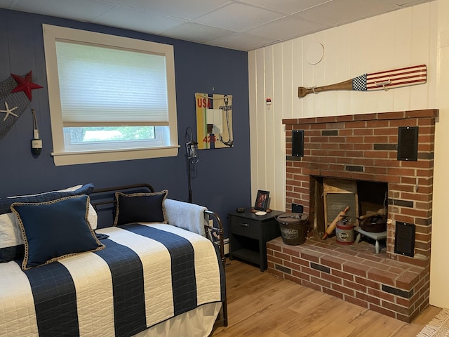 bedroom with a fireplace and wood finished floors