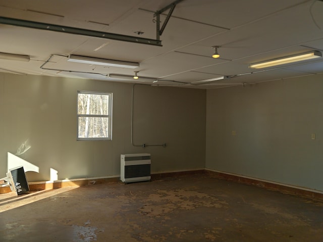 spare room featuring heating unit and unfinished concrete floors