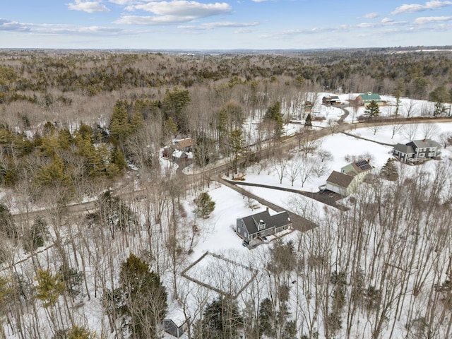 snowy aerial view featuring a forest view