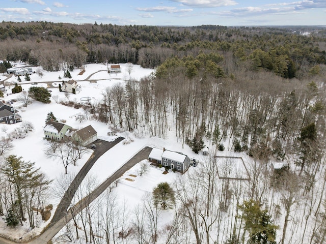 snowy aerial view with a wooded view