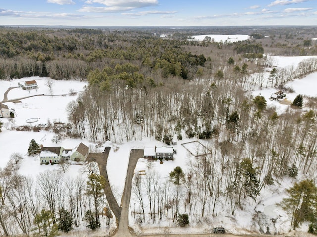 snowy aerial view featuring a forest view