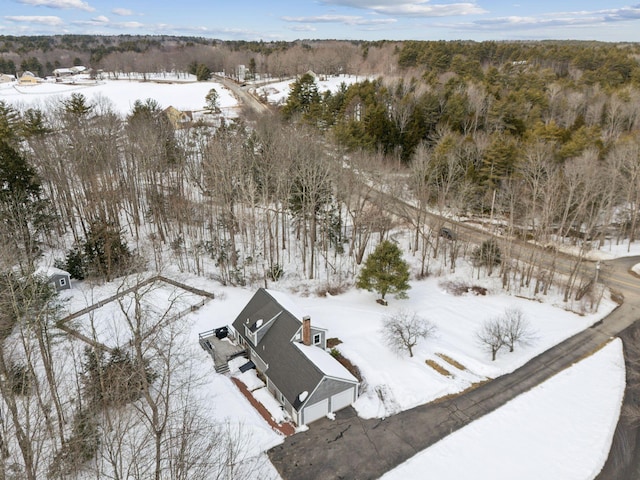 snowy aerial view featuring a forest view