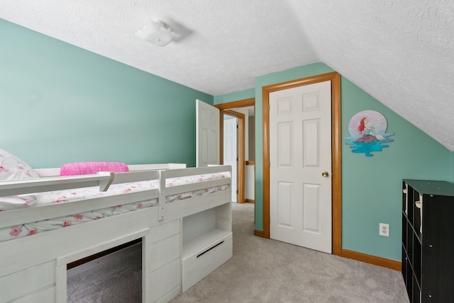 unfurnished bedroom with a textured ceiling, light carpet, lofted ceiling, and baseboards