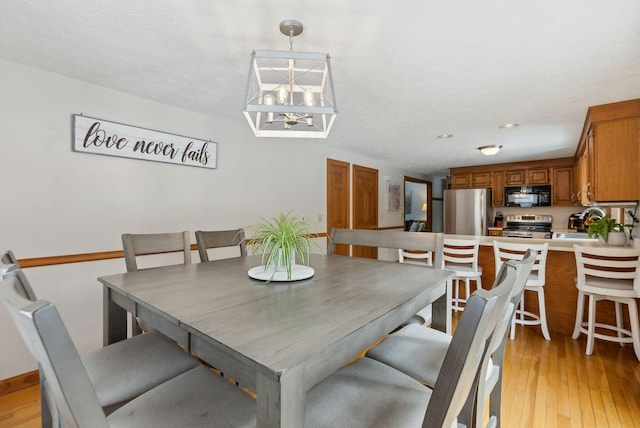 dining area with a chandelier and light wood finished floors