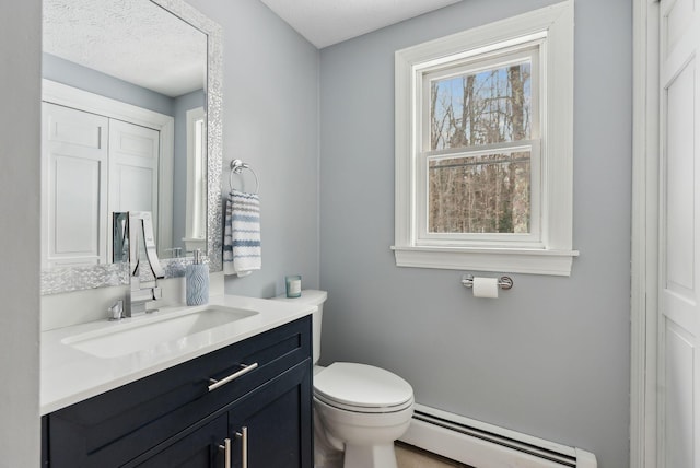 bathroom with baseboard heating, vanity, and toilet