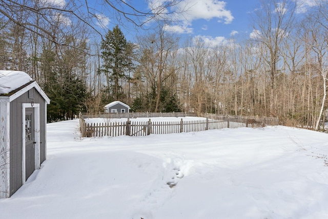 yard layered in snow with an outbuilding and fence private yard