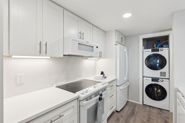 191 E Grand Ave Unit 606, Old Orchard Beach, ME 04064 - kitchen with white appliances, stacked washer / drying machine, white cabinetry, wood finished floors, and light countertops