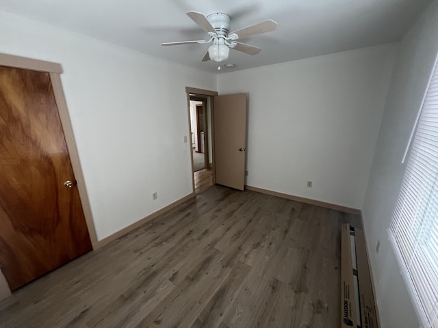 unfurnished bedroom featuring ceiling fan, baseboards, and wood finished floors