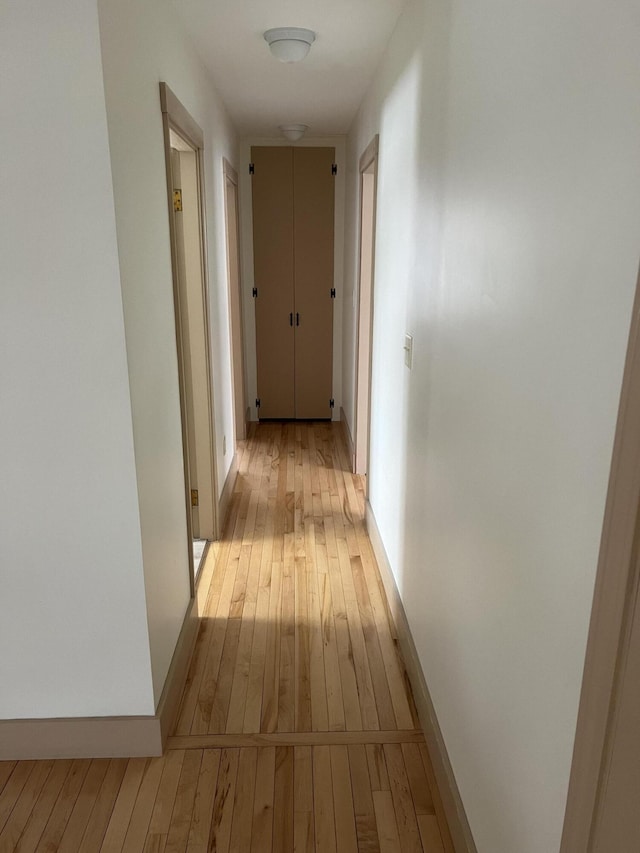 hall with light wood finished floors and baseboards