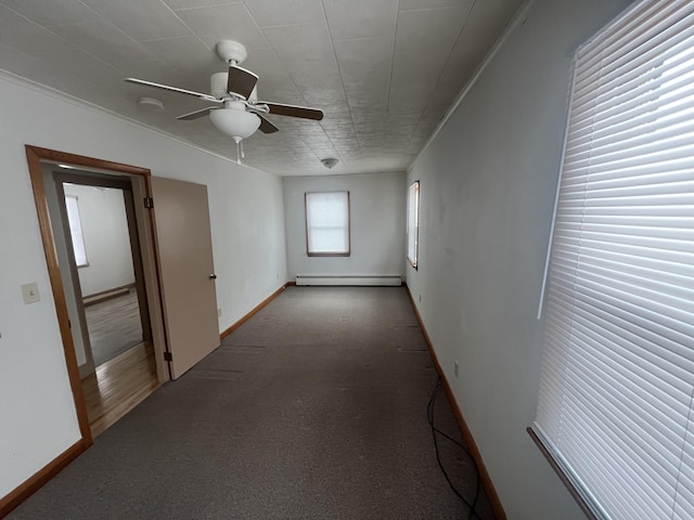 spare room with a baseboard radiator, baseboards, ceiling fan, and crown molding