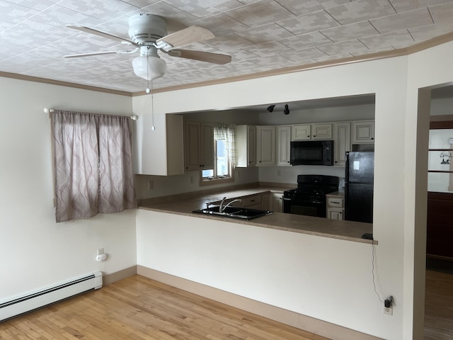 kitchen featuring a baseboard radiator, a sink, ornamental molding, light wood-type flooring, and black appliances