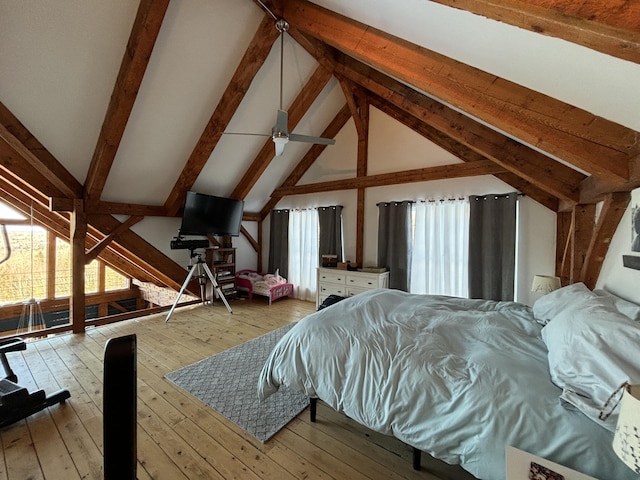 bedroom with lofted ceiling with beams, multiple windows, and hardwood / wood-style floors