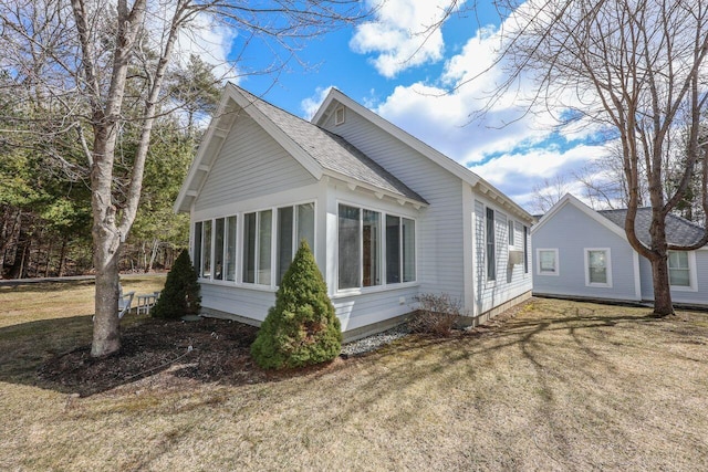 454 Post Rd Unit 128, Wells, ME 04090 - view of home's exterior with a shingled roof, a sunroom, and a yard