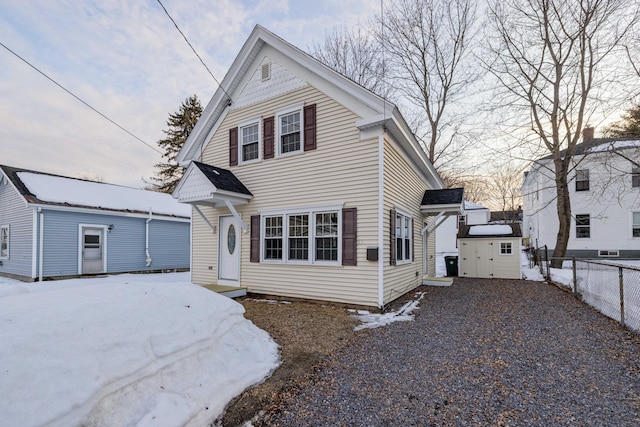 view of front of home with gravel driveway and fence