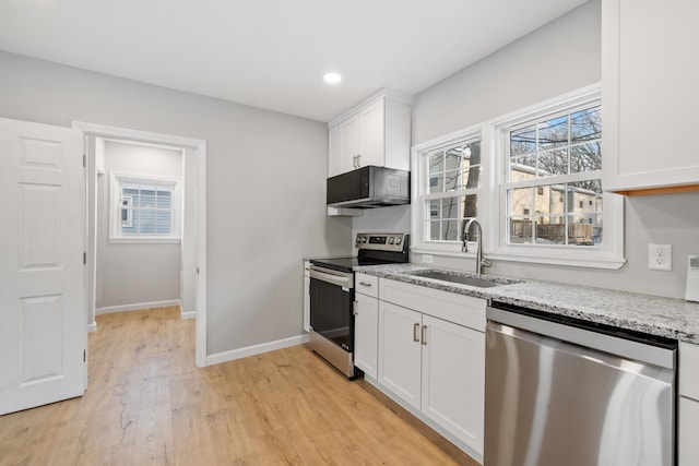 kitchen with stainless steel appliances, a sink, baseboards, white cabinets, and light stone countertops