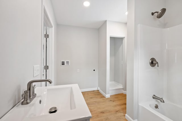 full bath featuring shower / bathtub combination, recessed lighting, a sink, wood finished floors, and baseboards