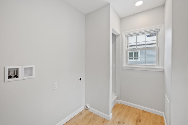 clothes washing area featuring laundry area, light wood-style flooring, baseboards, and electric dryer hookup