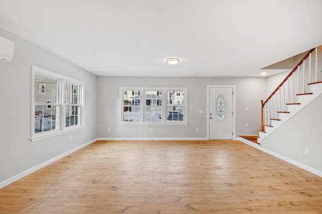 foyer entrance with baseboards, stairway, and light wood-style flooring