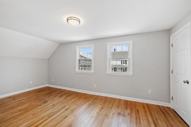 bonus room featuring vaulted ceiling, light wood finished floors, and baseboards