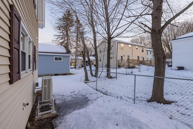 yard layered in snow featuring ac unit, fence, and a residential view