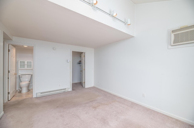 34 Parkwood Dr Unit 203, Augusta, ME 04330 - unfurnished bedroom featuring a baseboard radiator, carpet, a wall mounted AC, a walk in closet, and baseboards