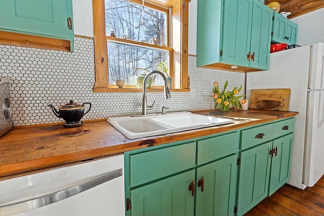 kitchen featuring tasteful backsplash, white appliances, a sink, and dark wood-style flooring