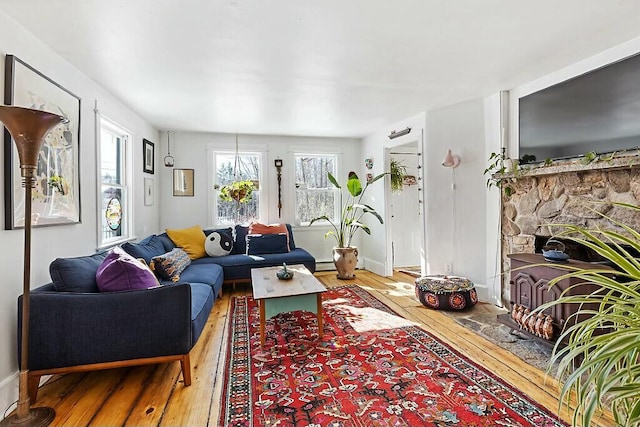 living room with hardwood / wood-style floors, a fireplace, and baseboards