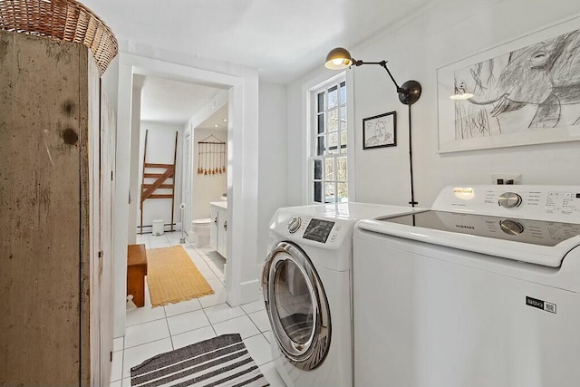 laundry room featuring light tile patterned floors, laundry area, and separate washer and dryer