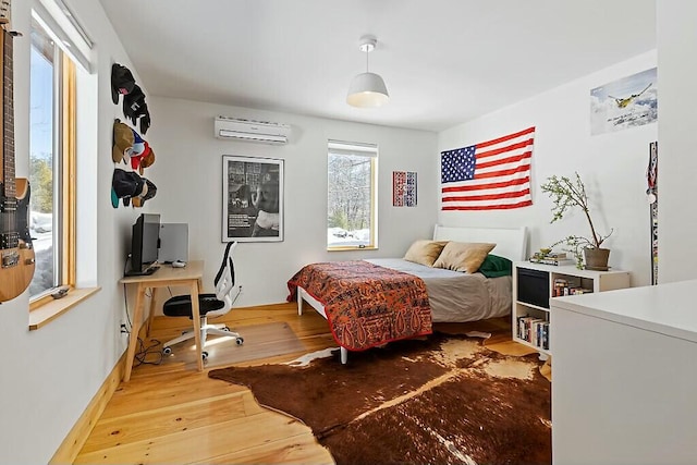 bedroom with a wall unit AC and hardwood / wood-style flooring