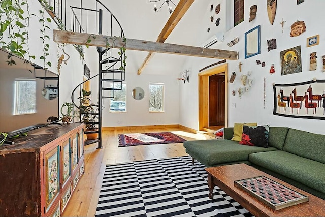 living room featuring light wood-type flooring, a healthy amount of sunlight, a high ceiling, and beamed ceiling