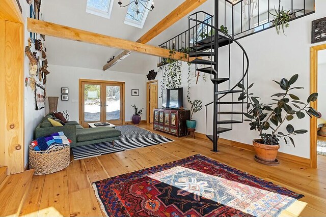 living room with hardwood / wood-style flooring, stairs, french doors, high vaulted ceiling, and beam ceiling