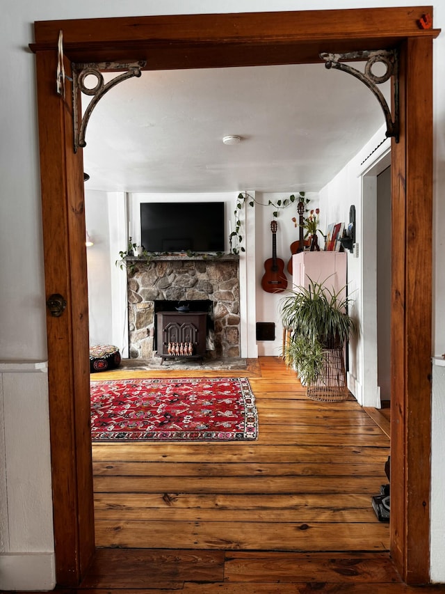 living room featuring arched walkways, a fireplace, and wood finished floors