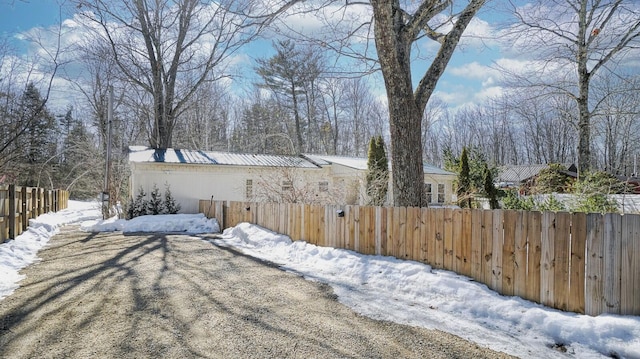 yard layered in snow featuring a fenced front yard