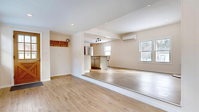 foyer with recessed lighting, light wood-style flooring, a wall mounted air conditioner, and baseboards