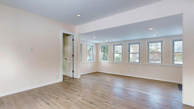 empty room featuring recessed lighting, baseboards, and wood finished floors