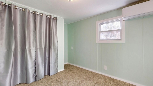 empty room featuring a wall mounted AC and carpet floors