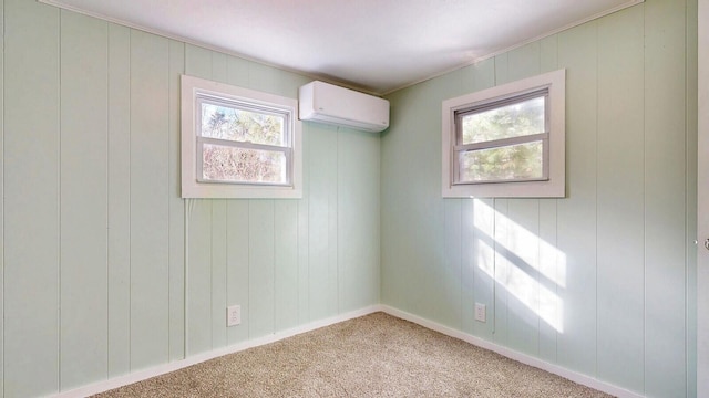 carpeted spare room featuring a wall mounted air conditioner and baseboards