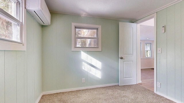 carpeted empty room with a wall mounted AC and baseboards