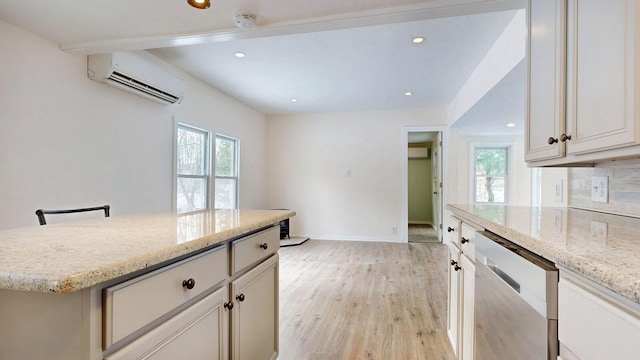 kitchen with light wood-type flooring, light stone countertops, tasteful backsplash, and an AC wall unit