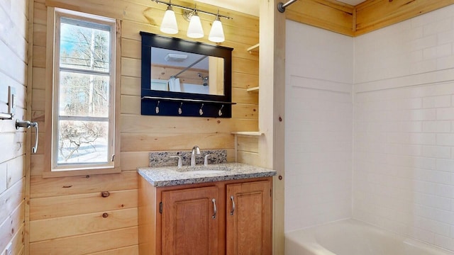 bathroom featuring vanity,  shower combination, and wooden walls