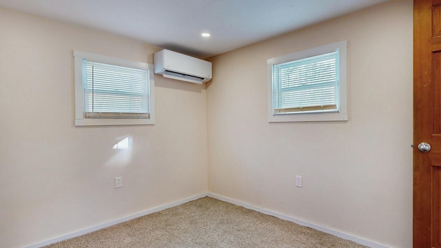 unfurnished room featuring recessed lighting, baseboards, a wall mounted air conditioner, and light carpet