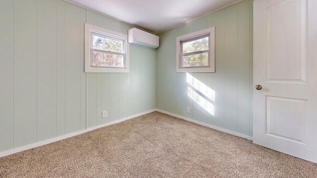 spare room with carpet, baseboards, and a wall mounted AC