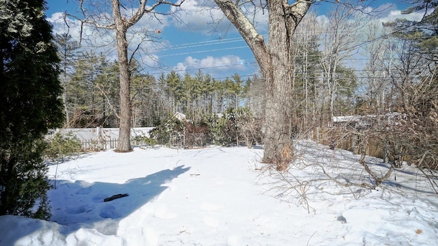 yard covered in snow featuring fence