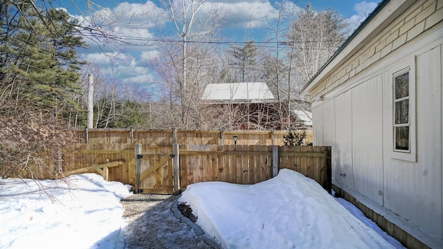 yard layered in snow with a gate and fence