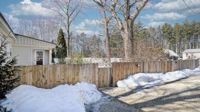 snowy yard featuring fence